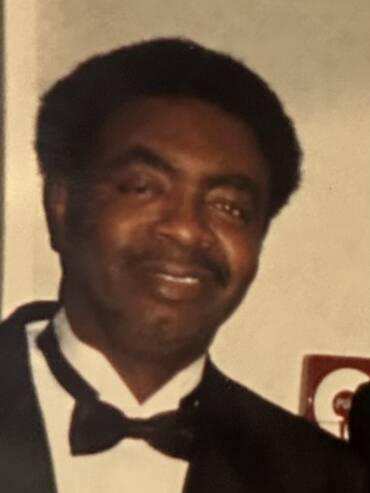 Man in tuxedo smiling at event.